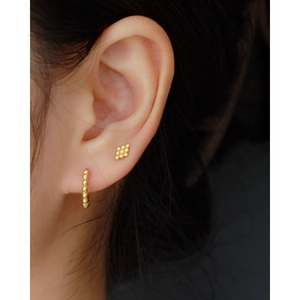 925 silver stud and hoop earring set in gold finish worn by a model in soft lighting