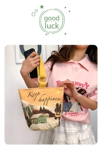 Detail of canvas bucket bag featuring winter rabbit illustration and wooden ring handle