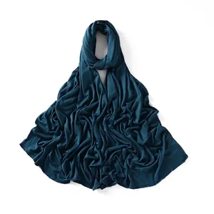 Detail of teal jersey hijab scarf with smooth texture and delicate stitched edges