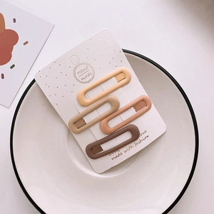 Detail view of 4 pieces matte oval BB hair clips in milk tea colors on display card