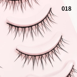 Detailopname van natuurlijke zwarte kunstwimpers model 018 op een roze gebogen tray