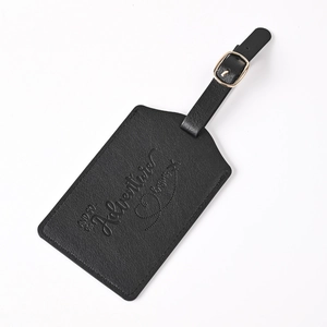 Detail shot of black PU leather luggage tag with Adventure Begins embossed text and metal buckle