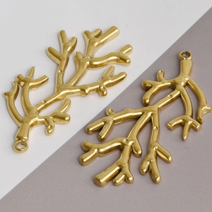 Detail of two golden stainless steel coral branch pendants for DIY jewelry making