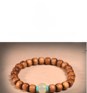 Macro detail of Thuja wood prayer beads with white jade center and blue spacers
