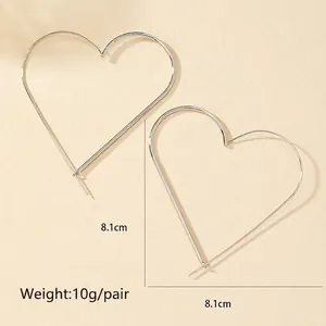 Detail view of large silver heart hoop earrings with 8.1cm diameter and 10g weight