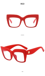 Macro view of red oversized square glasses frame with gold metal temple accent