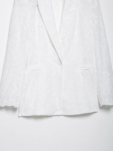 Gros plan détaillé de la broderie anglaise florale sur une veste blazer en coton blanc