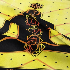 Detailed macro view of bohemian yoga tapestry with yellow chakra symbols and woven texture