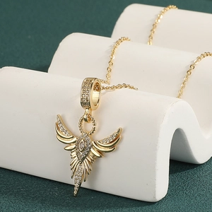 18K gold plated phoenix wing pendant necklace with sparkling cubic zirconia on white stand