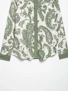 Close-up detail of paisley print long sleeve shirt with vintage patterns and green trim