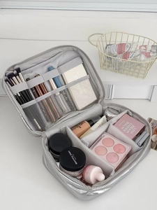Silver makeup bag detail showing interior compartments and adjustable dividers