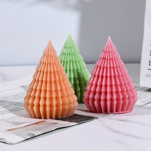 Geometric Christmas tree scented candles in orange green and pink on vintage newspaper
