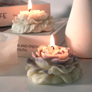 Blooming peony flower scented candles in green and gradient gray with lit wicks