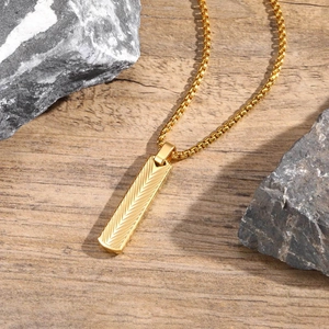 Macro shot of gold stainless steel rectangular pendant with fine feather texture