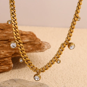 Golden cuban chain necklace featuring round white zircon pendants on a rock base