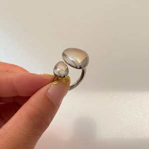 Detailed view of irregular polished silver ring with a minimalist double-stone design
