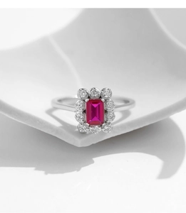 Close-up of S925 silver ring with rectangular pink stone on white ceramic base