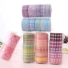Set of colorful grid pattern washi tape rolls in transparent creative stationery boxes