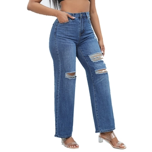 Dettaglio della trama denim consumata e dello strappo sui jeans a zampa blu chiaro