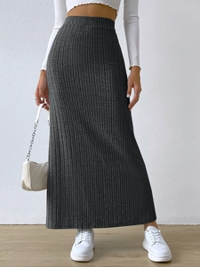 Detail shot of a dark grey ribbed knit maxi skirt featuring a high waist and side slit
