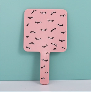 Pink square handheld makeup mirror with black eyelash pattern and ergonomic handle