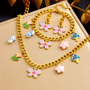 Détails d'un ensemble de bijoux dorés avec pendentifs émaillés papillon et fleur