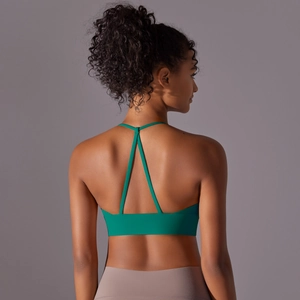 Detail of emerald green sports bra featuring criss-cross back straps and elastic band