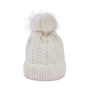 Detail view of white cable knit beanie texture with a fluffy white faux fur pompom top