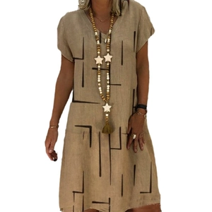 Detail of V-neck khaki cotton dress featuring black geometric line patterns and star necklace