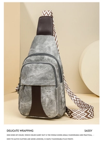 Detail of grey crossbody sling bag with brown leather trim and patterned wide shoulder strap