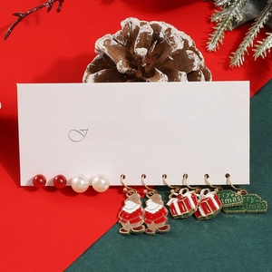 Five pairs of Christmas earrings set featuring Santa and gift box charms on festive backdrop