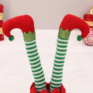 Detail of red and green striped Christmas elf legs made from velvet and knit fabrics