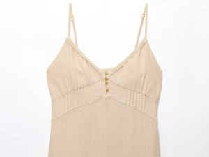 Détail d'une robe midi en lin avec bordure en dentelle et boutons décoratifs en bois