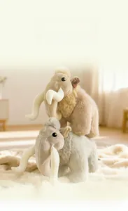 Close-up of soft mammoth plush toys in grey and brown on a white fluffy rug