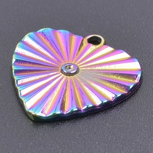 Macro shot of rainbow heart pendant with radial texture and center crystal inlay