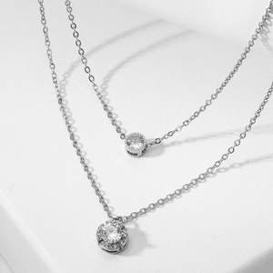 Silver layered necklace with sparkling round zircon pendants on a clean white background