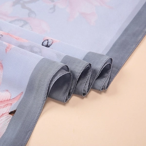 Macro shot of elegant light blue silk scarf with floral prints and fine sewn edges