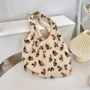 Detail of plush floral tote bag showing soft fleece texture and colorful woven label
