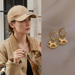 Golden rocking horse pendant hoop earrings with detailed metal craftsmanship for women