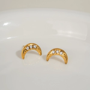Detailed view of gold crescent moon stud earrings with three inlaid sparkling clear gemstones