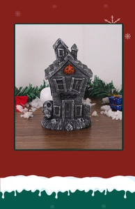 Close-up of a miniature Halloween ghost house ornament with pumpkin and Boo lettering