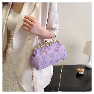 Detail of purple lace embroidery evening bag with 3D floral petals and gold metal ring handle
