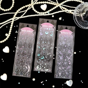 Macro shot of 3D laser silver stickers with moon and butterfly themes for journals