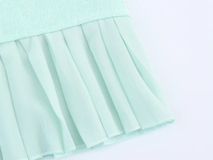 Detail of mint green tweed fabric with pleated chiffon hemline on this sleeveless dress