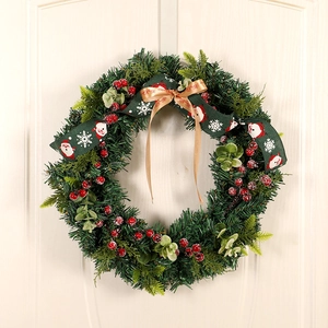 Artificial Christmas wreath with red berries, pine needles and Merry Christmas ribbons