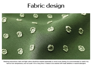 Detailed macro view of green fabric with embroidered polka dots and laundry instructions