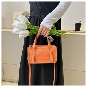 Detail of orange faux crocodile texture on a stylish square tote bag with handles