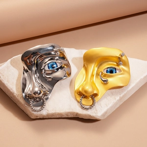 Broches visage abstrait en métal doré mat et argent poli sur support en pierre