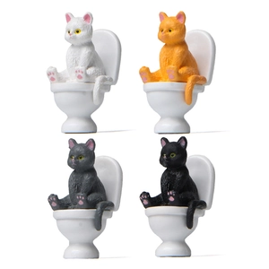 Creative miniature cat figurines sitting on white toilets in 4 different colors