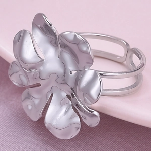 Dettaglio dell'anello a fiore argento con fascia regolabile su superficie rosa